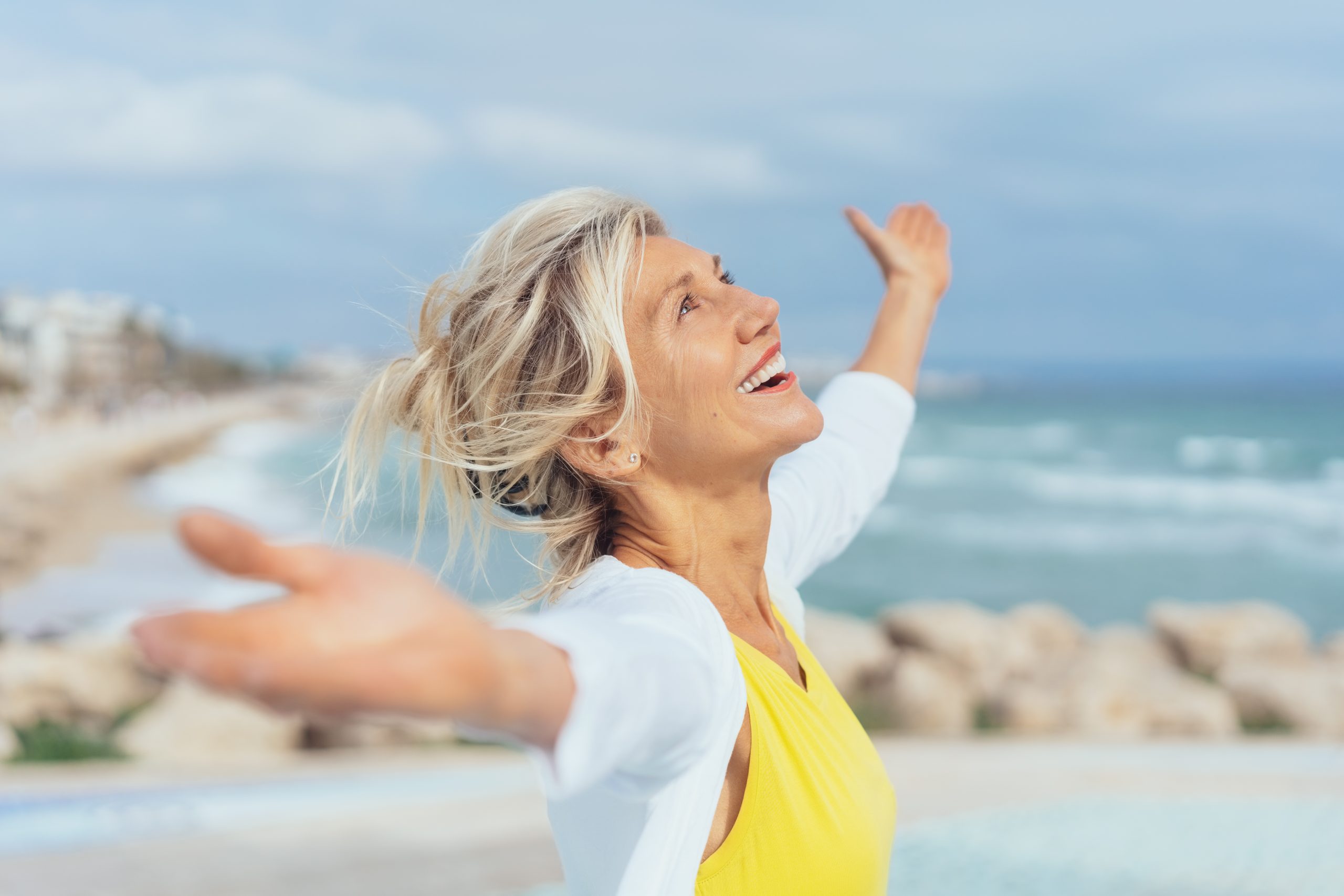 Joyful woman enjoying the freedom of the beach How to find your happiness habits